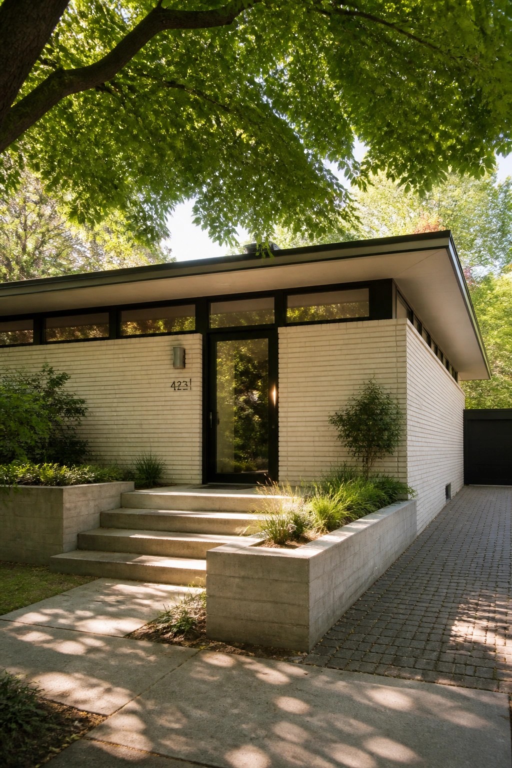 A modern single-story house with a flat roof, white brick exterior, black-framed door and windows, and concrete steps with integrated planters at the entrance.