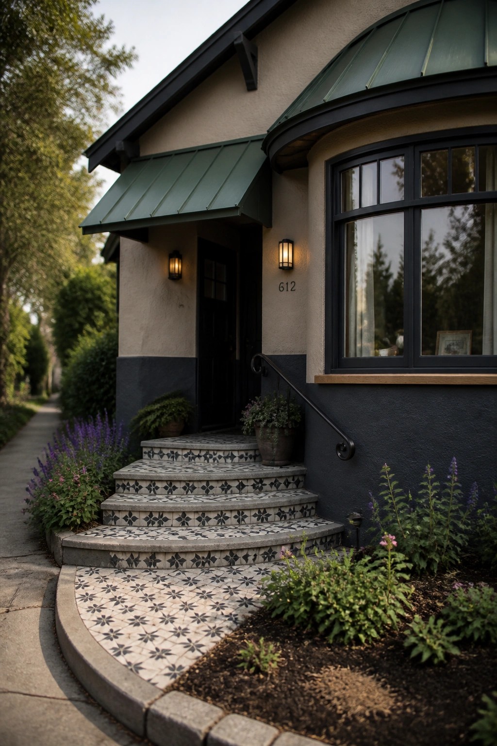 Front entrance of a house with patterned tile on the steps and curved walkway, a black door, green awnings, and a large multi-pane window.